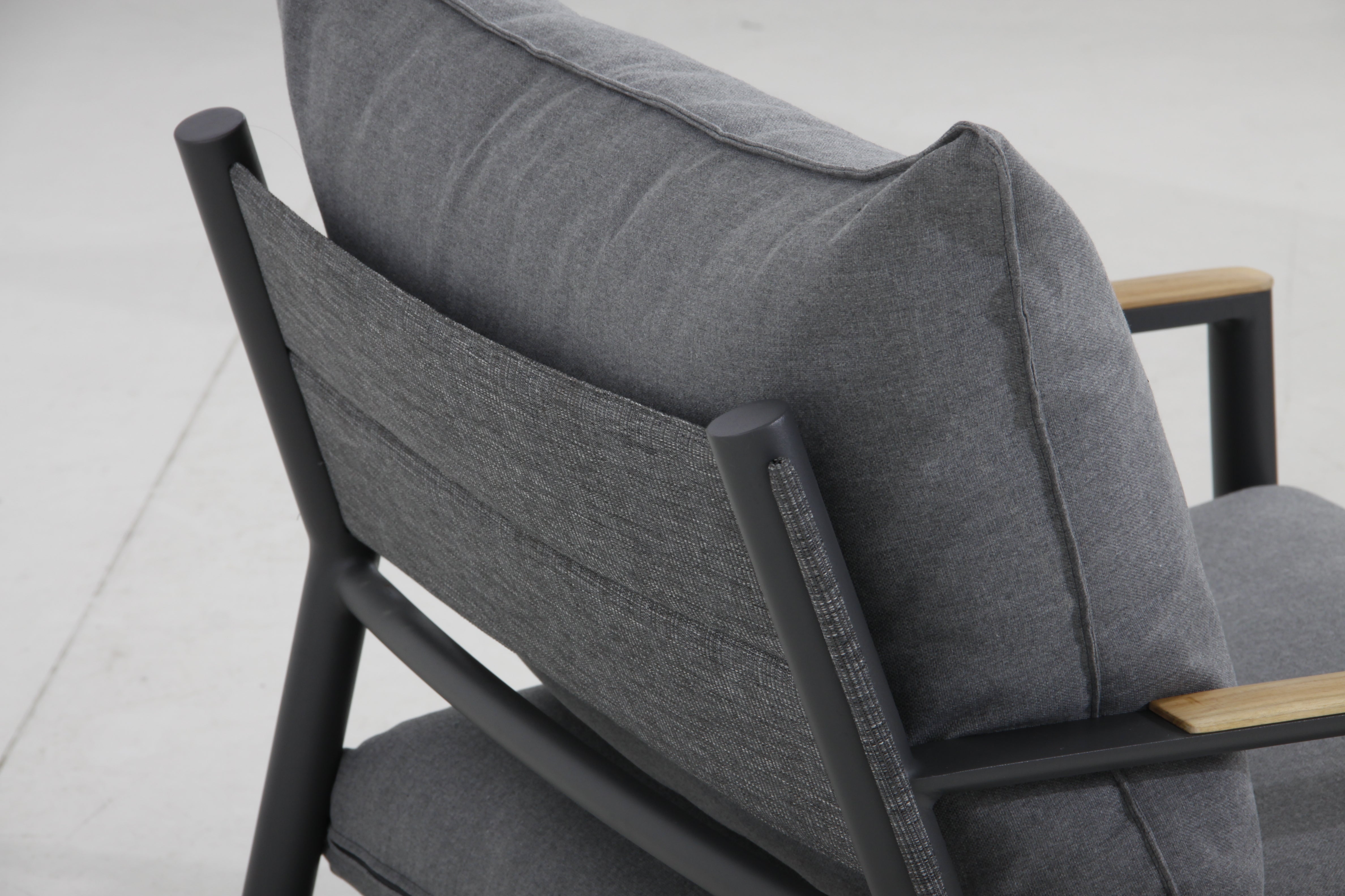 Close-up view from the back of the Monti sectional set, showcasing the cushions and teak wood armrests.